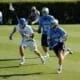 Duke Lacrosse long stick midfielder LSM pursues the NorthCarolina midfielder carrying the ball